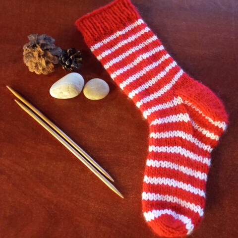 Knitted red and white striped sock with red cuff, heel and toe 

[material: acryl]